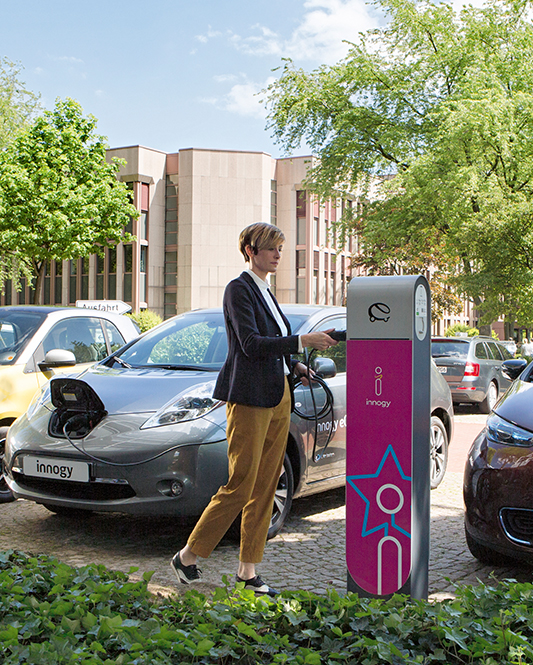 Frau schließt ihr eAuto an eine innogy Ladesäule an